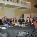 Image of people sitting at a table smiling