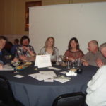 Image of people sitting at a table smiling