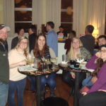 Image of group of people sitting at table posing for picture