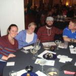 Image of people sitting at a table smiling