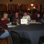 Image of people sitting at a table smiling