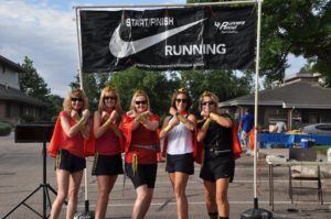 Image of 5 ladies wearing capes at start/finish line