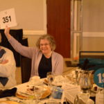 Image of woman holding up a number
